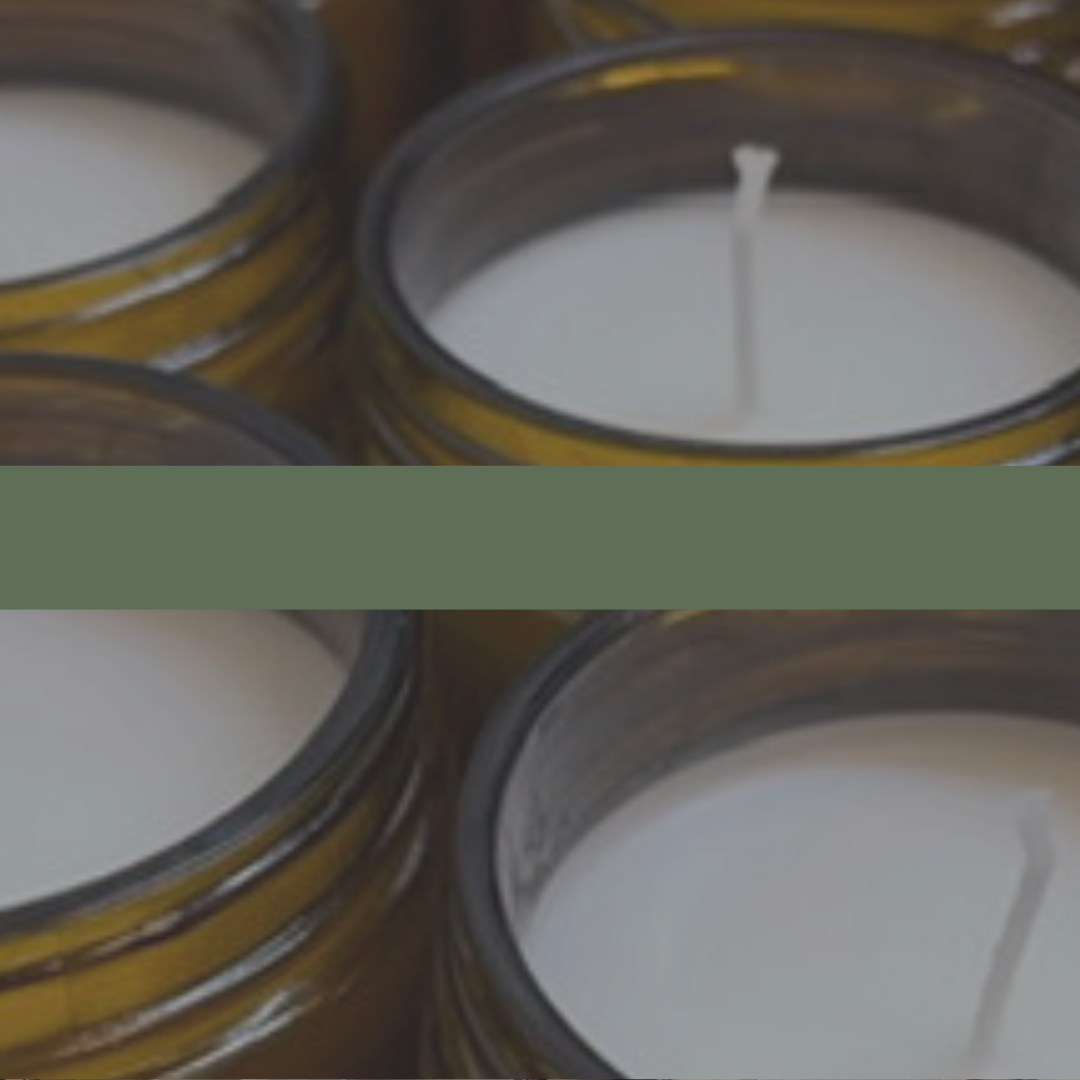 Close-up of several candles in glass jars with a dark overlay